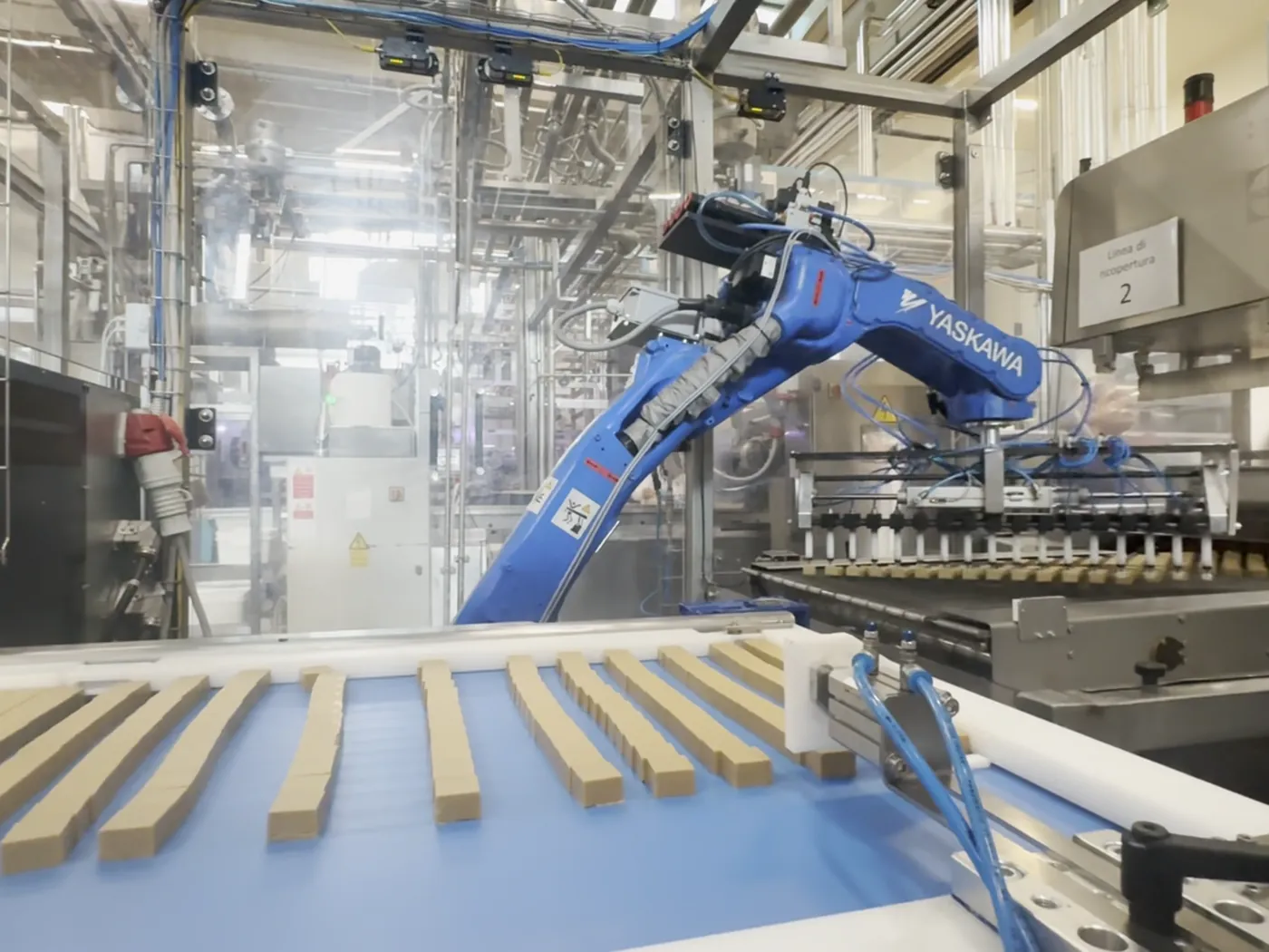 Robot Yaskawa che preleva le barrette di cioccolato dal nastro e le dispone distanziate
